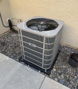 New residential outdoor air conditioning condenser unit installed next to home exterior wall - Ac Pro